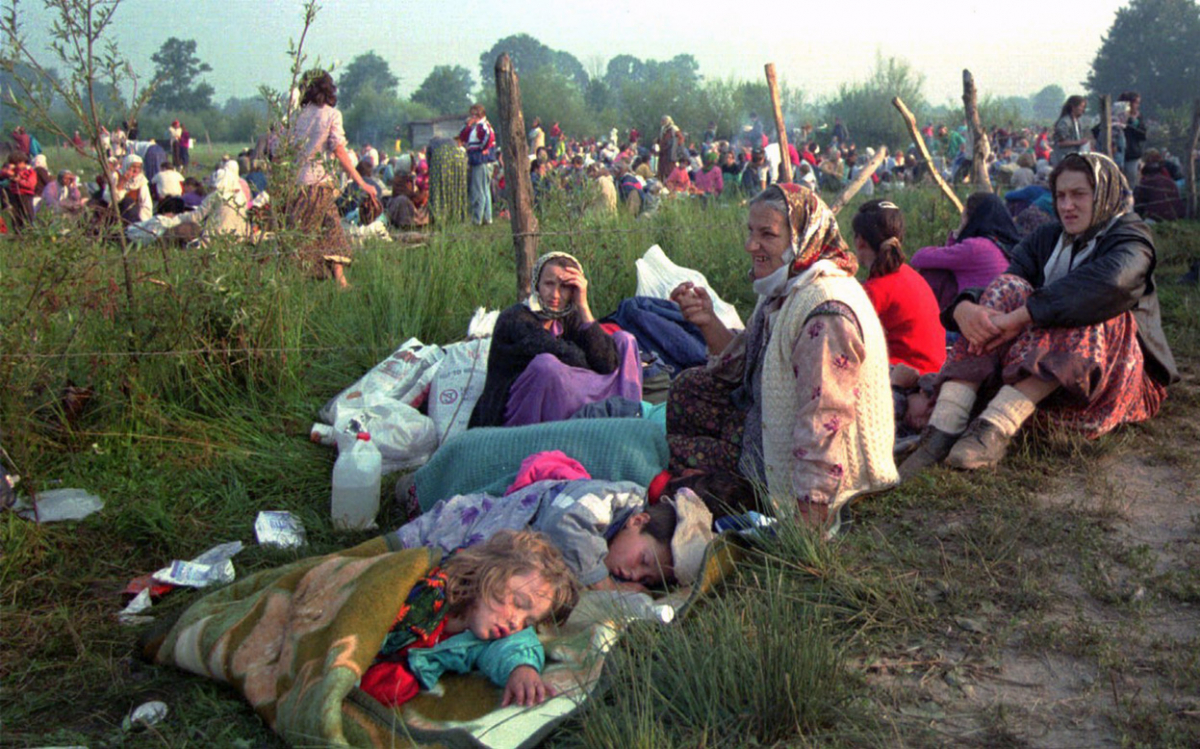 Бегалци од Сребреница се собираат пред базата на О.Н. во Тузла, на 14-ти јули 1995-та.