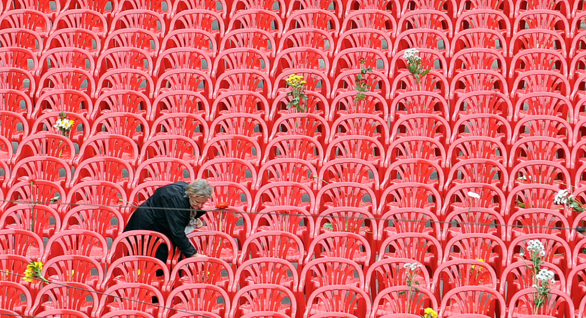 Постара жена остава цвеќе на неколку од 11.451 празни столици поставени на главната улица во Сараево, кои треба да ги симболизираат 11.451 жртва на опсадата на градот.