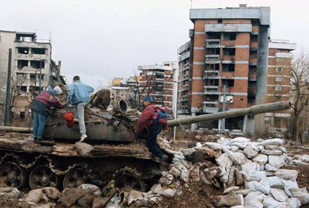 (пред) Уништен тенк пред зграда во населбата Ковачичи во Сараево, февруари 1996.