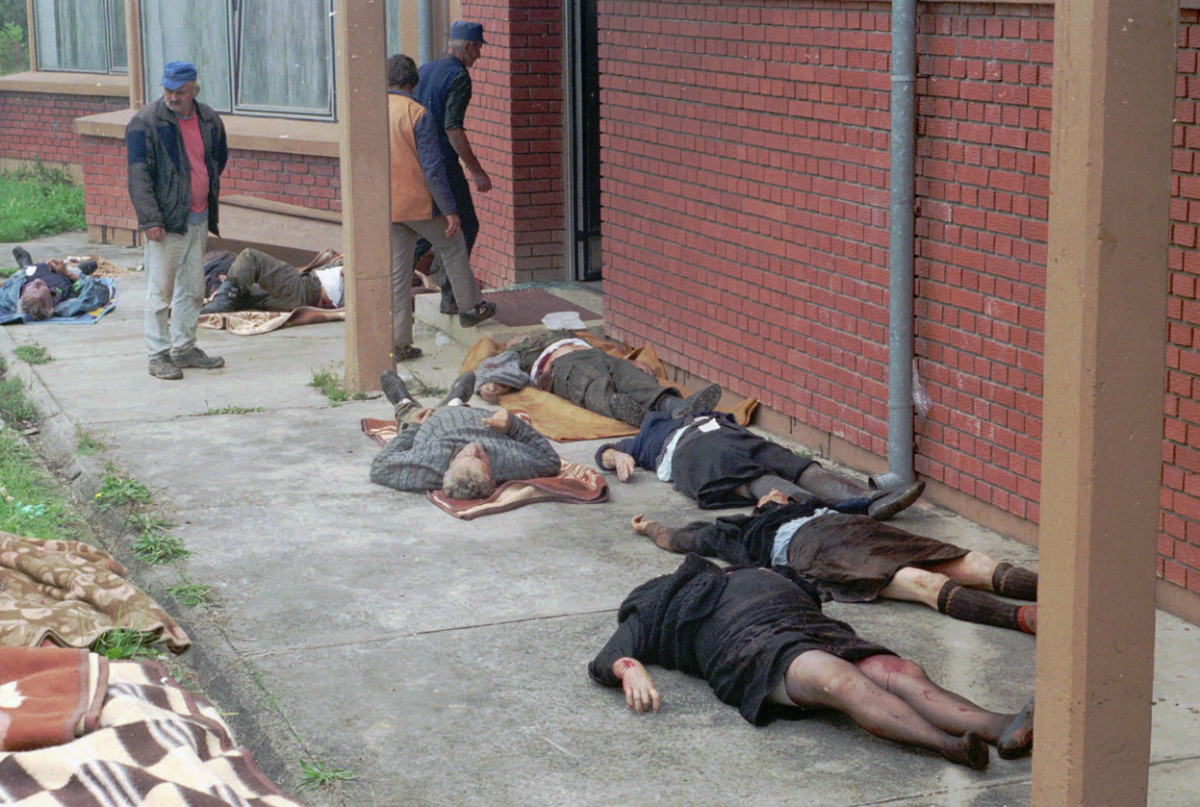 Луѓето гледаат во телата на српските цивили убиени во нападот на хрватските командоси, на градот Босанска Дубица.