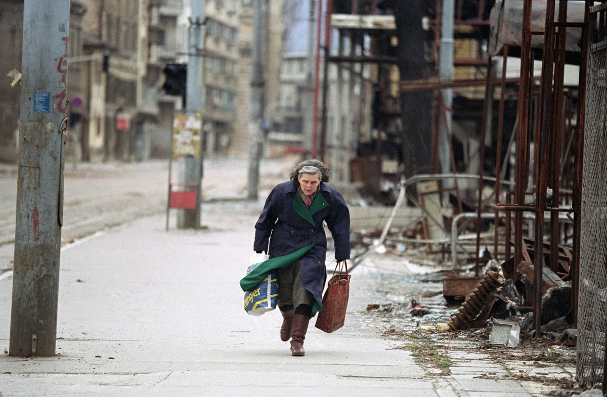 На патот кон дома, жената претрчува покрај уништените продавници во најопасниот дел од т.н. Снајперски сокак. 8-ми април 1993.