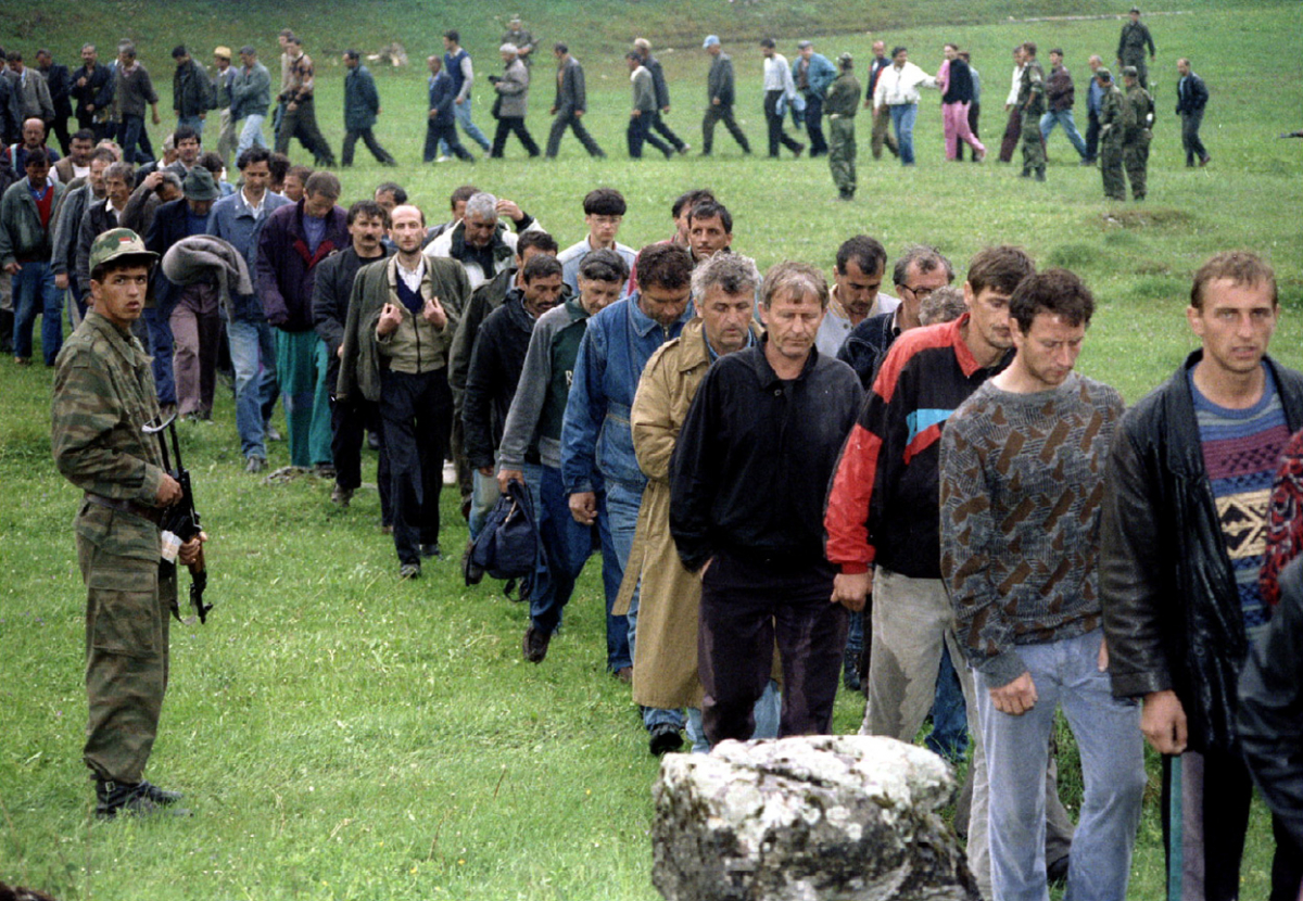 Војници на босанските Хрвати, заробени минуваат покрај босански Србин откако се предале на планината Власиќ. Околу 7.000 хрватски цивили и 700 војници пребегаа на српска територија по тешкото бомбардирање од босанските муслимани.