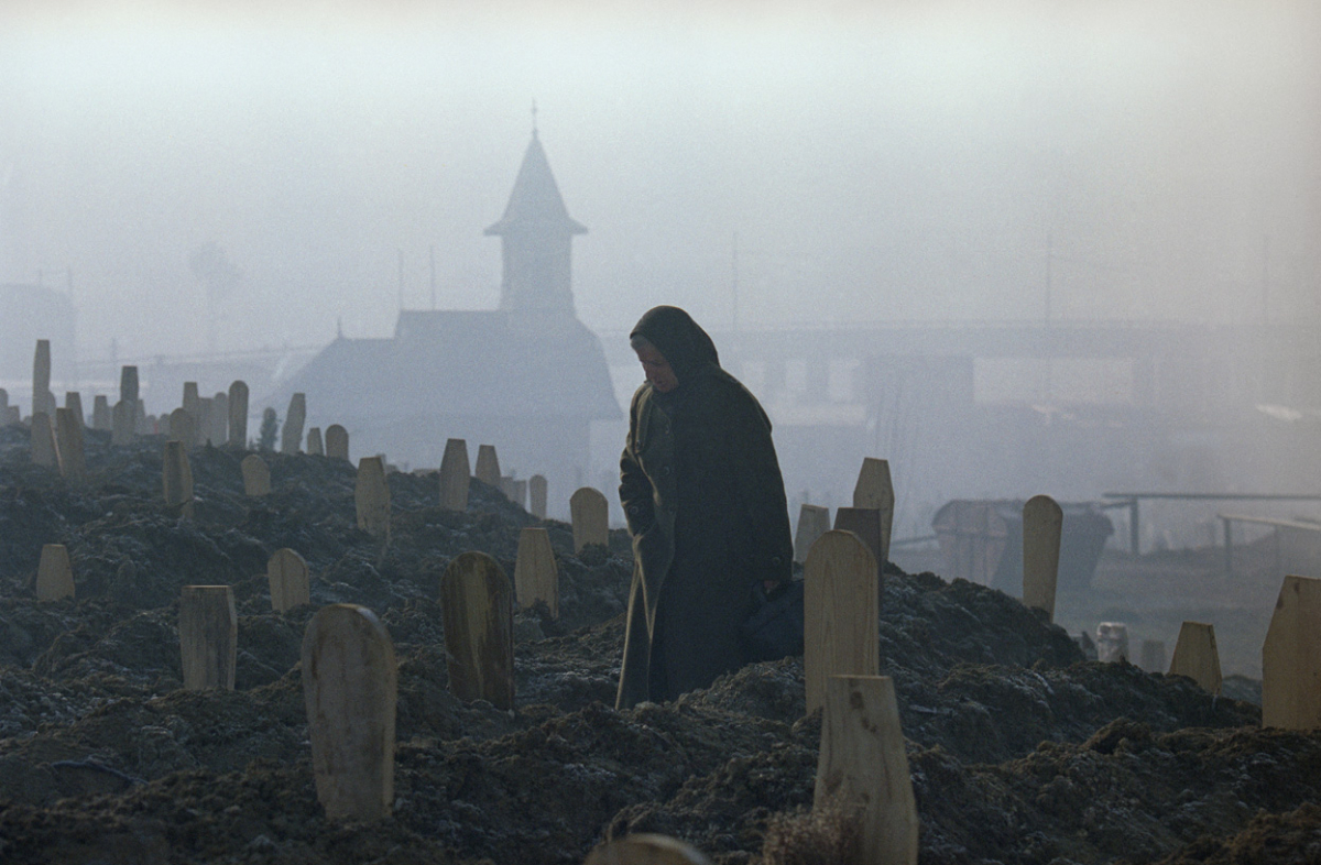 Жена стои над тазе ископаните гробови во Сараево. Најголемиот број луѓе одеа на гробишта кога има магла за да ги сокрие од снајперски оган. 17-ти јануари 1993.